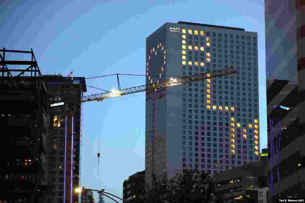 U.S. -- Lit windows at the Seattle Hyatt Regency Hotel display a heart and "BLM" for Black Lives Matter, Thursday, June 18, 2020, in downtown Seattle. Road blocks and other protests have taken place nightly in Seattle as people demand police reforms and p