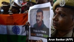 Indian security forces pose with the national flag and pictures of Indian Air Force pilot Abhinandan Varthaman during an event to pray for his return, at Kalikambal temple in Chennai on March 1.