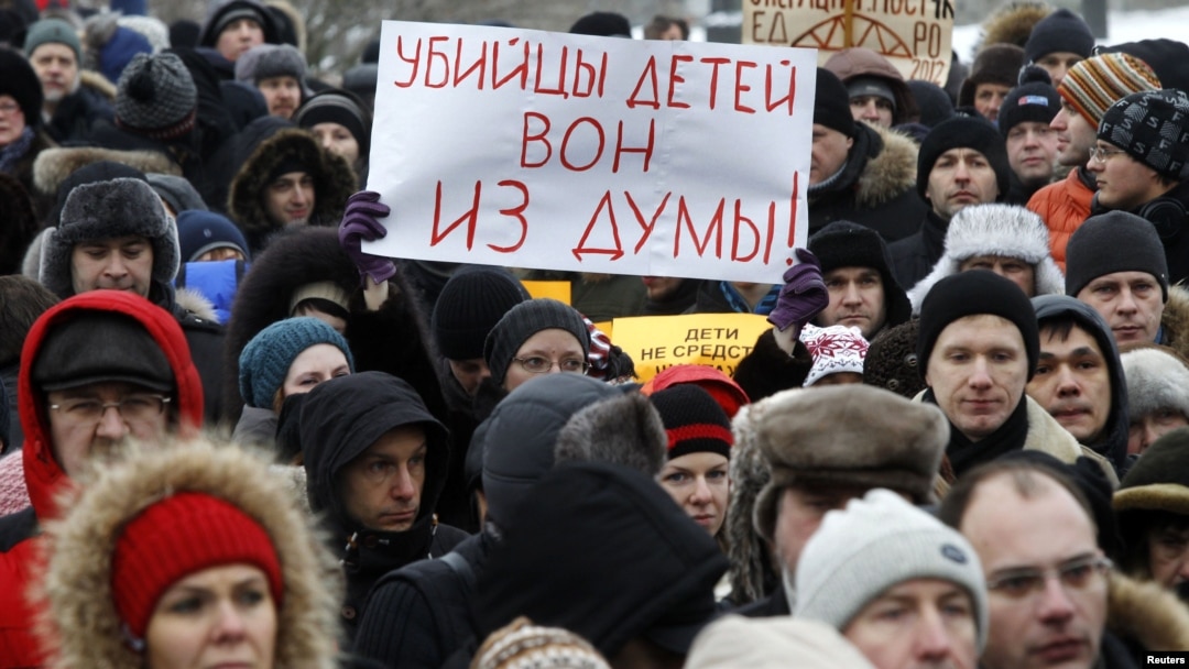 Protesters rally against the law banning Americans from adopting Russian children in St. Petersburg on January 13. The sign reads, "Murderers of children, get out of the Duma."