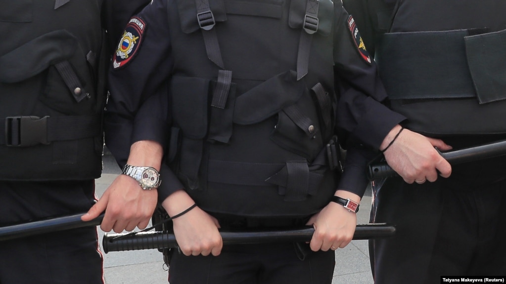 Police stand guard during a rally to demand authorities allow opposition candidates to run in the upcoming local election in Moscow in August.