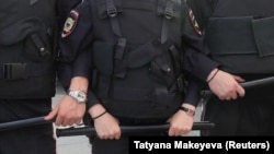 Police stand guard during a rally to demand authorities allow opposition candidates to run in the upcoming local election in Moscow in August.