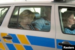 Jana Nagyova sits in a police car after being arrested for abuse of power and bribery.