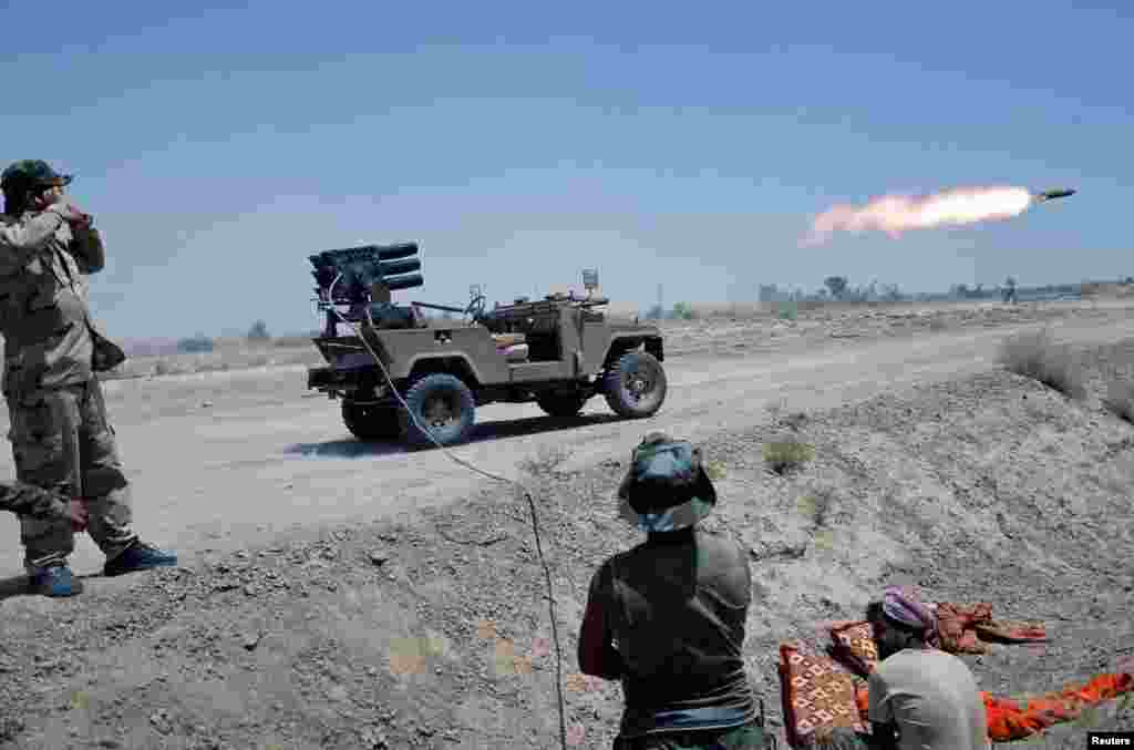 Iraqi Shi'ite paramilitaries launch a rocket toward Islamic State militants north of Fallujah in Anbar Province. (Reuters)