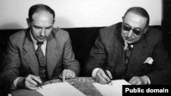 احمد قوام (راست) و ایوان سادچیکف در حال امضای قراردادی که به اشغال شوروی پایان داد.