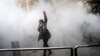A young woman raises her fist aloft as Iranian students clash with riot police in Tehran during antigovernment protests that rocked Iran for around two weeks at the turn of the year. 