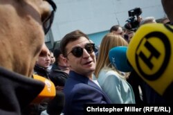 Zelenskiy reacts to a question from RFE/RL as he arrives at a polling station in Kyiv to vote.