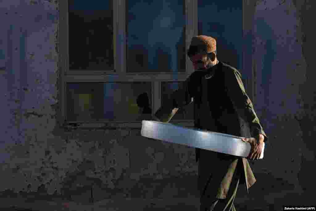 An Afghan man carries a block of ice in the city of Ghazni. (AFP/Zakeria Hashimi)