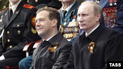 President Dmitry Medvedev (left) and Prime Minister Vladimir Putin watch the military parade in Moscow