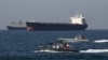 Iranian naval forces take part in the "National Persian Gulf day" in the Strait of Hormuz, April 30, 2019, with oil tankers in the background.