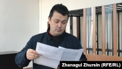 Ақтөбелік белсенді Әлібек Молдиннің 15 күндік қамаудан соң сот залына жеткізілген беті. 22 қараша 2019 жыл, Ақтөбе қалалық сотының ғимараты
