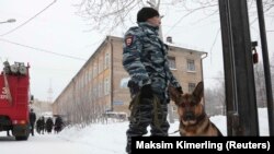 Полицейский со служебной собакой рядом со школой № 127 в Перми. 15 января 2018 года.