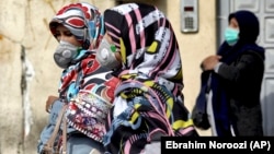 Women wearing protective masks in downtown Tehran.