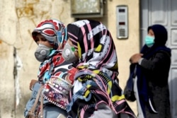 Люди в защитных масках на улицах Тегерана, 23 февраля 2020 года.
