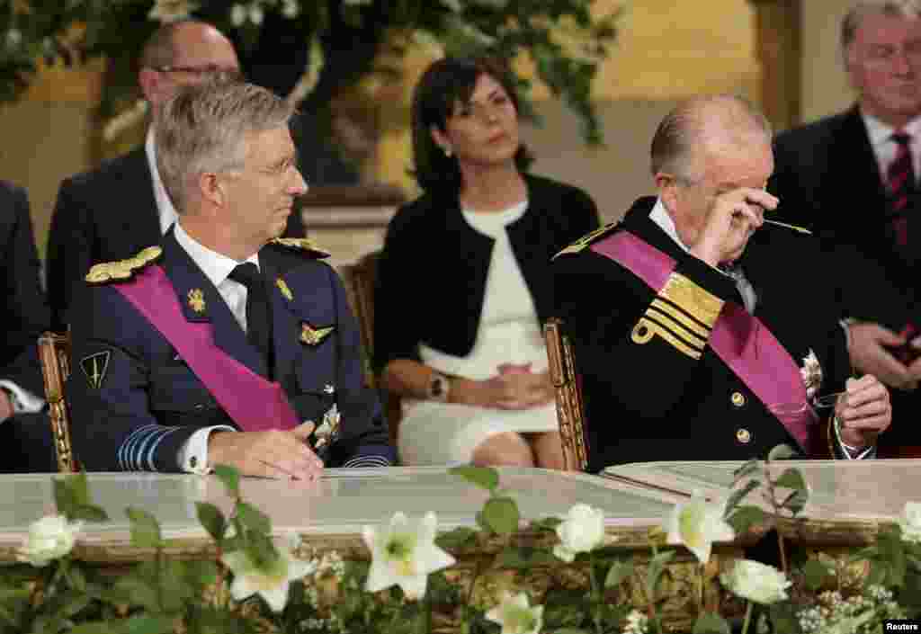 King Albert II (right) of Belgium, watched by son Crown Prince Philippe, wipes his eyes after signing an act of abdication to hand Philippe the throne during a ceremony at the Royal Palace on Belgian National Day in Brussels. (Reuters/Philippe Wojazer)