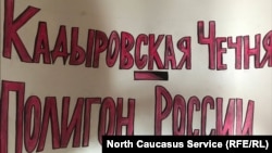 28 шо долчу Москварчу яхархочо ша ФСБ-н цIенна хьалха пикете хIотто йоьдуш караэцна хилла плакат. "Кадыровн Нохчийчоь. Оьрсийчоьнан полигон".
