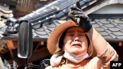 A woman cries as she speaks of her house, collapsed by an earthquake, in Japan's Kumamoto prefecture on April 15.