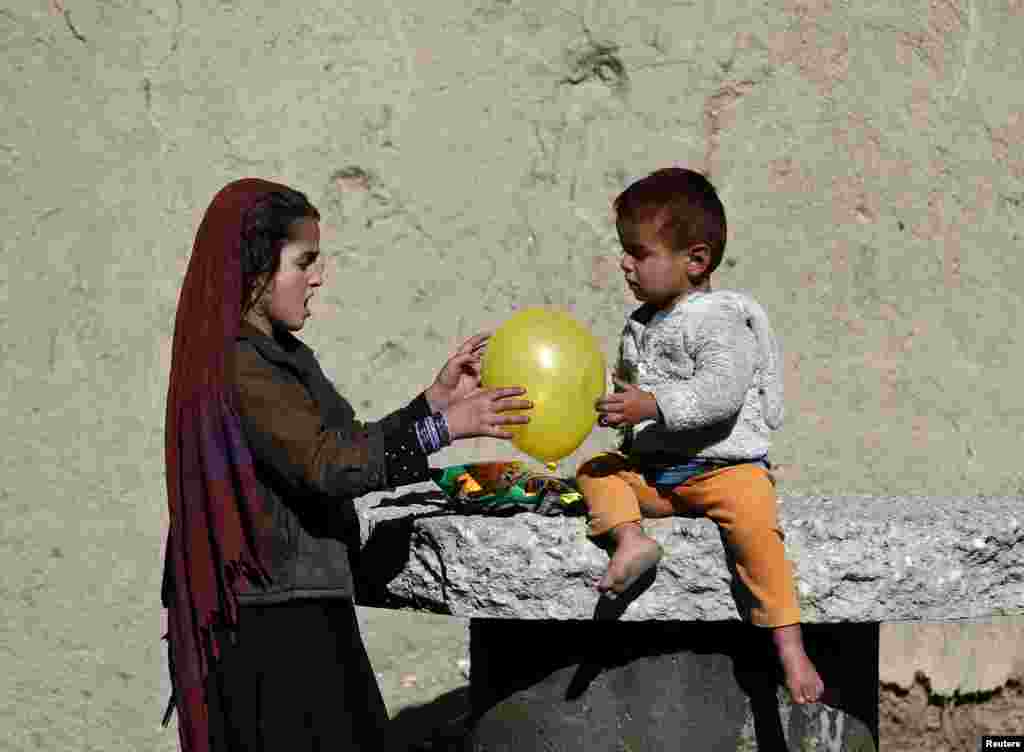 Afghan children play with a balloon outside their house in Kabul. (Reuters/​Omar Sobhani)