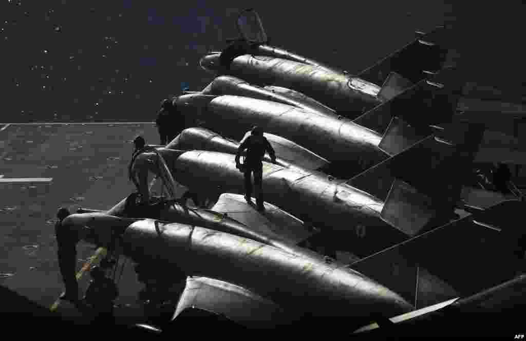 French sailors work on Super Etendard jet fighters on the flight deck of the French Charles-de-Gaulle aircraft carrier in the eastern Mediterranean Sea on November 22. (AFP/Anne-Christine Poujoulat)