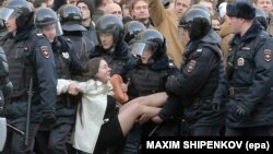 Russian riot police detain a demonstrator during an opposition rally in central Moscow on March 26, 2017.