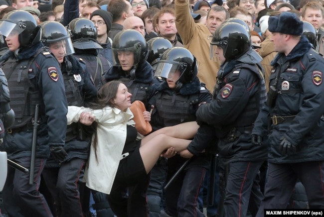 Russian riot police detain a woman during a protest in Moscow on March 26.