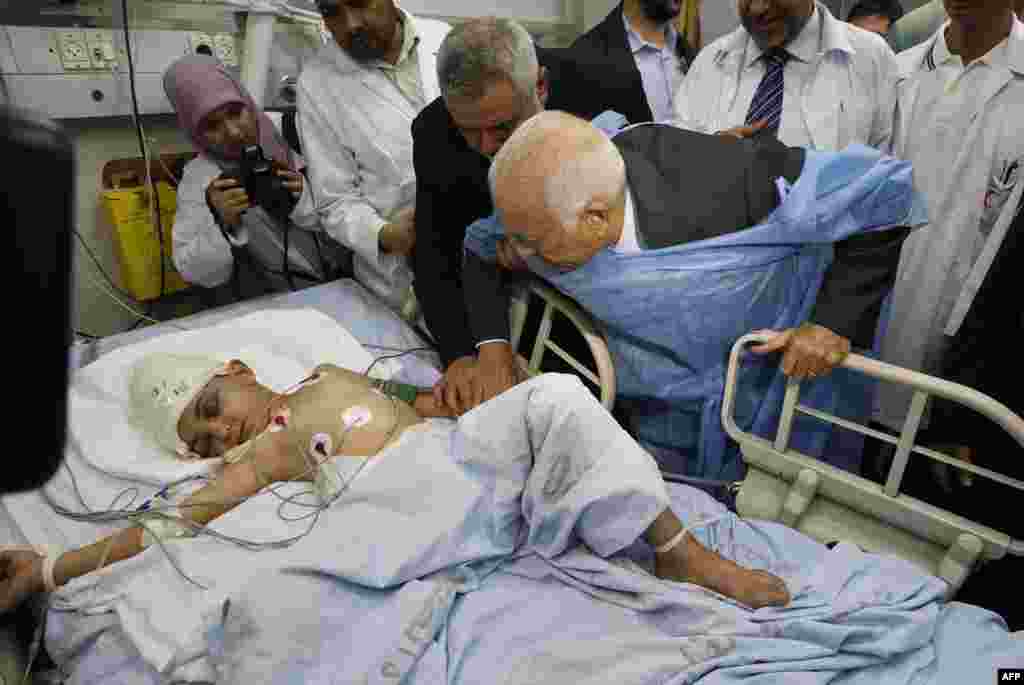 Arab League Secretary-General Nabil Elaraby (center right) and senior Hamas leader Ismail Haniyah (third from left) visit a boy who Palestinian medics say was wounded in an Israeli air strike at a hospital in Gaza City. (AFP/Ahmed Zakot)