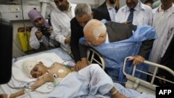 Arab League Secretary-General Nabil Elaraby (center right) and senior Hamas leader Ismail Haniyah (third from left) visit a boy who Palestinian medics say was wounded in an Israeli air strike at a hospital in Gaza City.