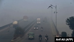 Commuters drive in heavy smog conditions in Lahore on November 21. 