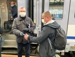 Працівники посольства України в Чехії допомагають українським пасажирам знайти свої місця у потязі, Прага, 19 березня 2020 року