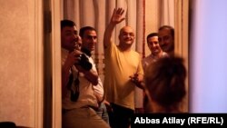 Azerbaijani journalist Eynulla Fatullayev waves to onlookers from his home in Baku after his release from prison in May 2011.