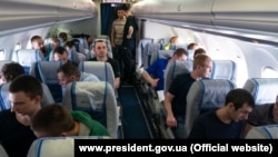 زندانیان آزاد شدۀ اوکراینی در داخل طیاره‌ی که در یکی از میدان های هوایی اوکراین نشست کرده است.