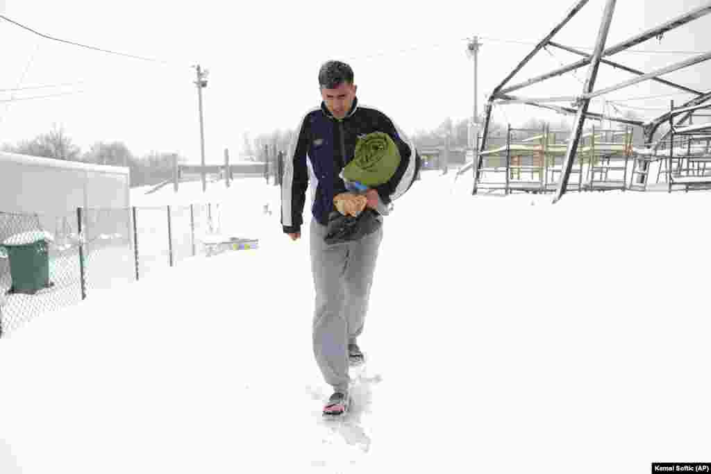 A resident walks through the snow at the camp. The fire in Lipa broke out after the IOM, due to the lack of a decision by the authorities on finding accommodation for migrants, began withdrawing from the camp on December 23. That left around 1,400 men stranded in a squalid, burnt-out tent camp in Bosnia as heavy snow fell.