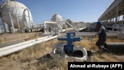 IRAQ -- An Iraqi oil employee turns a valve as he checks pipelines at the Bai Hassan oil field, west of the multi-ethnic northern Iraqi city of Kirkuk, October 19, 2017