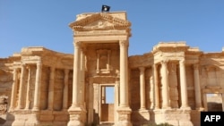 A video grab allegedly shows a flag of the Islamic State (IS) group at a Roman theater in the ancient city of Palmyra.