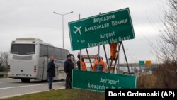 Muncitorii schimbă indicatorul spre Aeroportul de la Skopje, care a fost redenumit recent de către guvernul macedonean, 24 februarie 2018