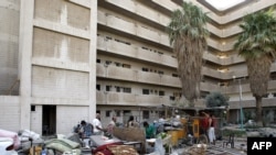 Iraqis salvage items from a building that was hit in a twin truck bombing near the Foreign Ministry in Baghdad.