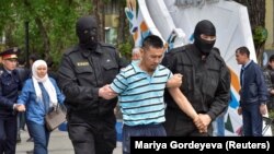 Kazakh policemen detain an opposition supporter during a protest rally in Almaty on May 10.