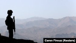 FILE: A Pakistan soldier stands guard along the border fence outside outpost on the border with Afghanistan in North Waziristan.