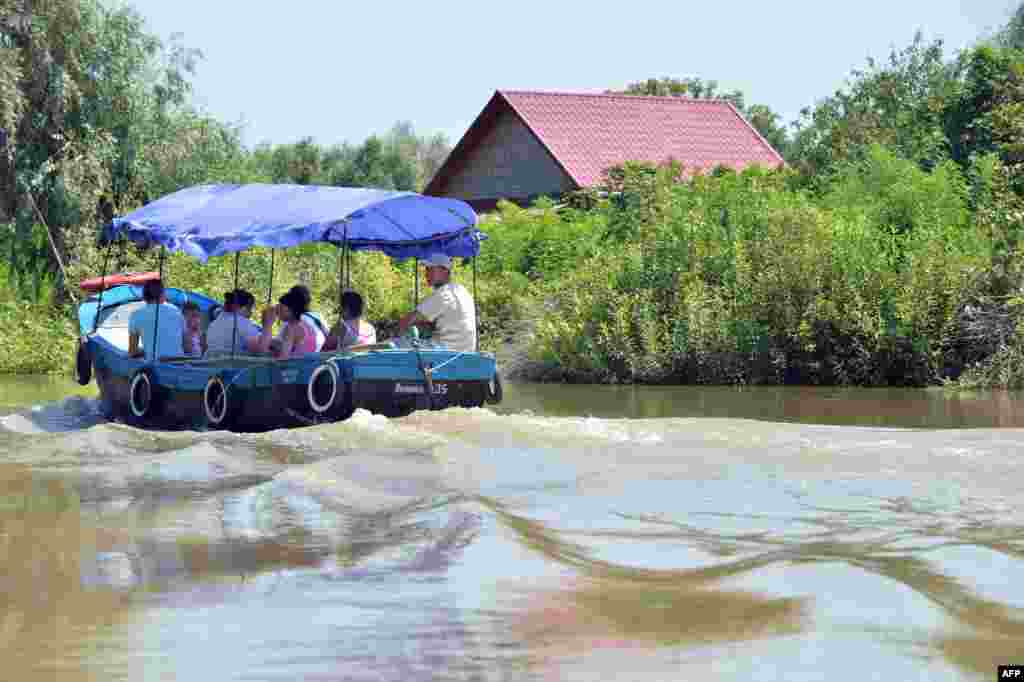 Tourists take a sightseeing trip on one of the town's many river channels.