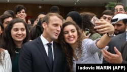 French President Emmanuel Macron poses for selfies with students at Paris-Sorbonne University Abu Dhabi on November 9.