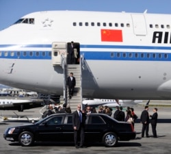 Сі спускається з борту свого літака на землю Сполучених Штатів у 2012 році