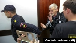 Russian historian Yury Dmitriyev is escorted into a courtroom in the city of Petrozavodsk on June 29.