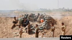 Kurdish Peshmerga forces clash with Islamic State militants in the town of Daquq, south of Kirkuk, on September 30.