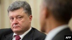 Ukrainian President Petro Poroshenko (left) listens as President Barack Obama talks during their bilateral meeting in the Oval Office of the White House in Washington on September 18.