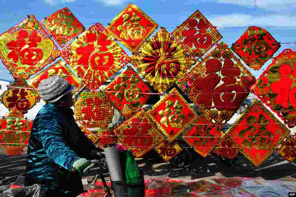 People buy lunar new year decorations with the Chinese word for luck in a market in Zouping in eastern Shandong Province. The lunar new year falls on February 10. (AFP)