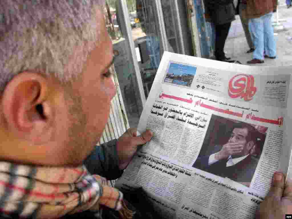 Iraq -- An Iraqi man reads the headlines of a newspaper as he follows the news on Saddam's trial and sentencing in Baghdad, 27Dec2006 - Bu räsemdä ber ğiraqlı 27 Dikäber gäzitendä Xösäyengä çığarılğan qarar turında uqıy. (epa)