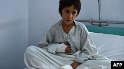 A wounded Afghan boy, a survivor of the U.S. air strikes on the MSF hospital in Kunduz, sits on his bed at a hospital in Kabul run by the Italian aid organization known as Emergency.