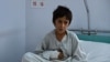 A wounded Afghan boy, survivor of the US airstrikes on the MSF Hospital in Kunduz, sits on his bed at the Italian aid organization, Emergency's hospital in Kabul on October 6.