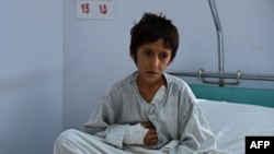 A wounded Afghan boy, survivor of the US airstrikes on the MSF Hospital in Kunduz, sits on his bed at the Italian aid organization, Emergency's hospital in Kabul on October 6.