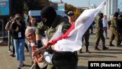 Белорусский силовик задерживает Багинскую во время протестов в Минске, сентябрь 2020 года
