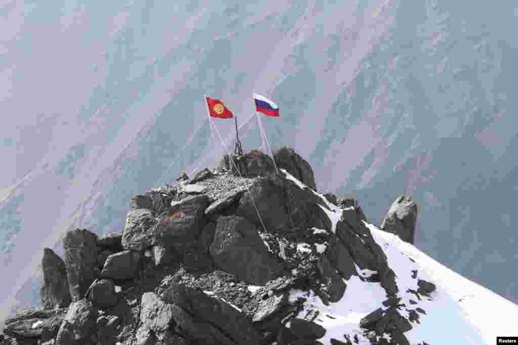 The Kyrgyz and Russian flags fly at the summit of Vladimir Putin Peak. 